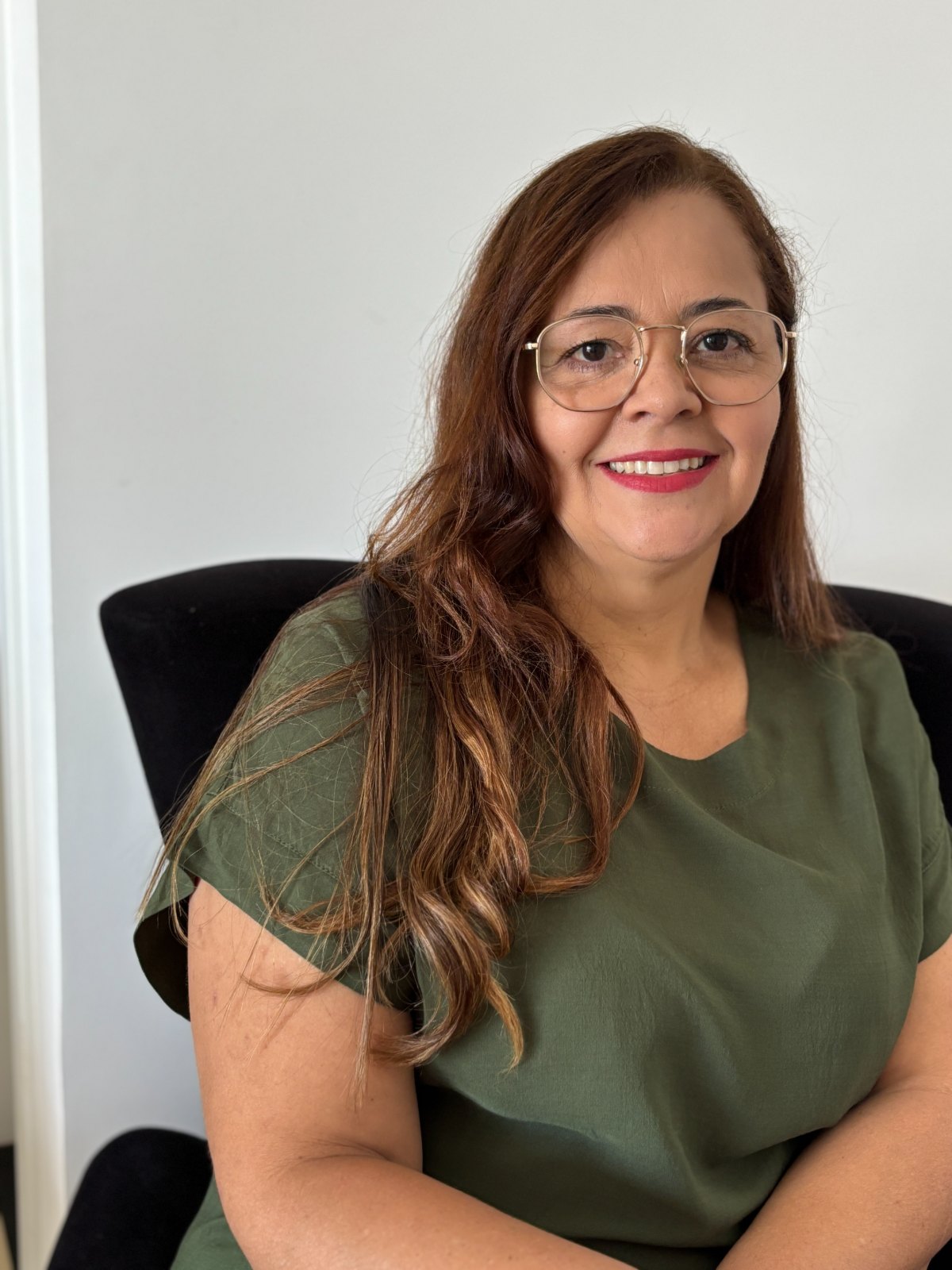 Retrato de Silvane Abreu, psicóloga, sorrindo em seu consultório.